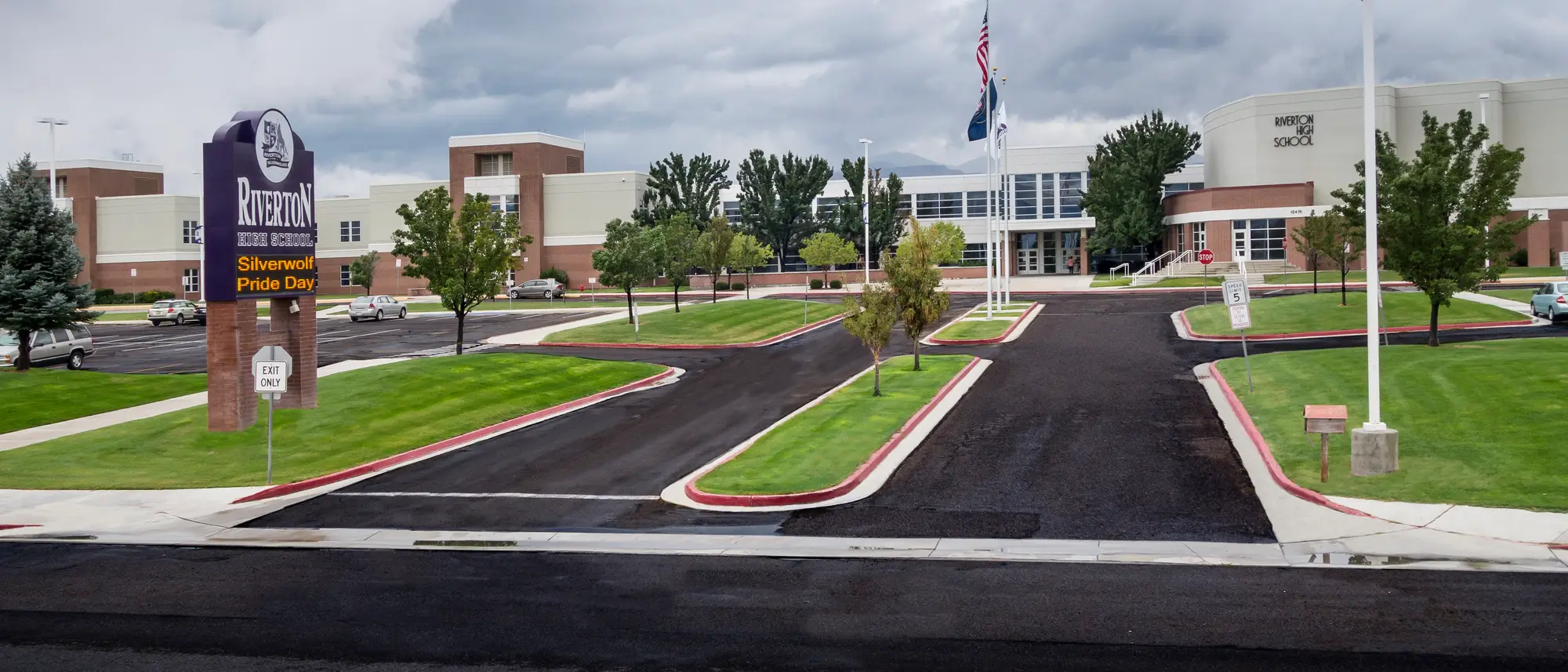 The main entrance and frontage of Riverton High School under a clear sky.
